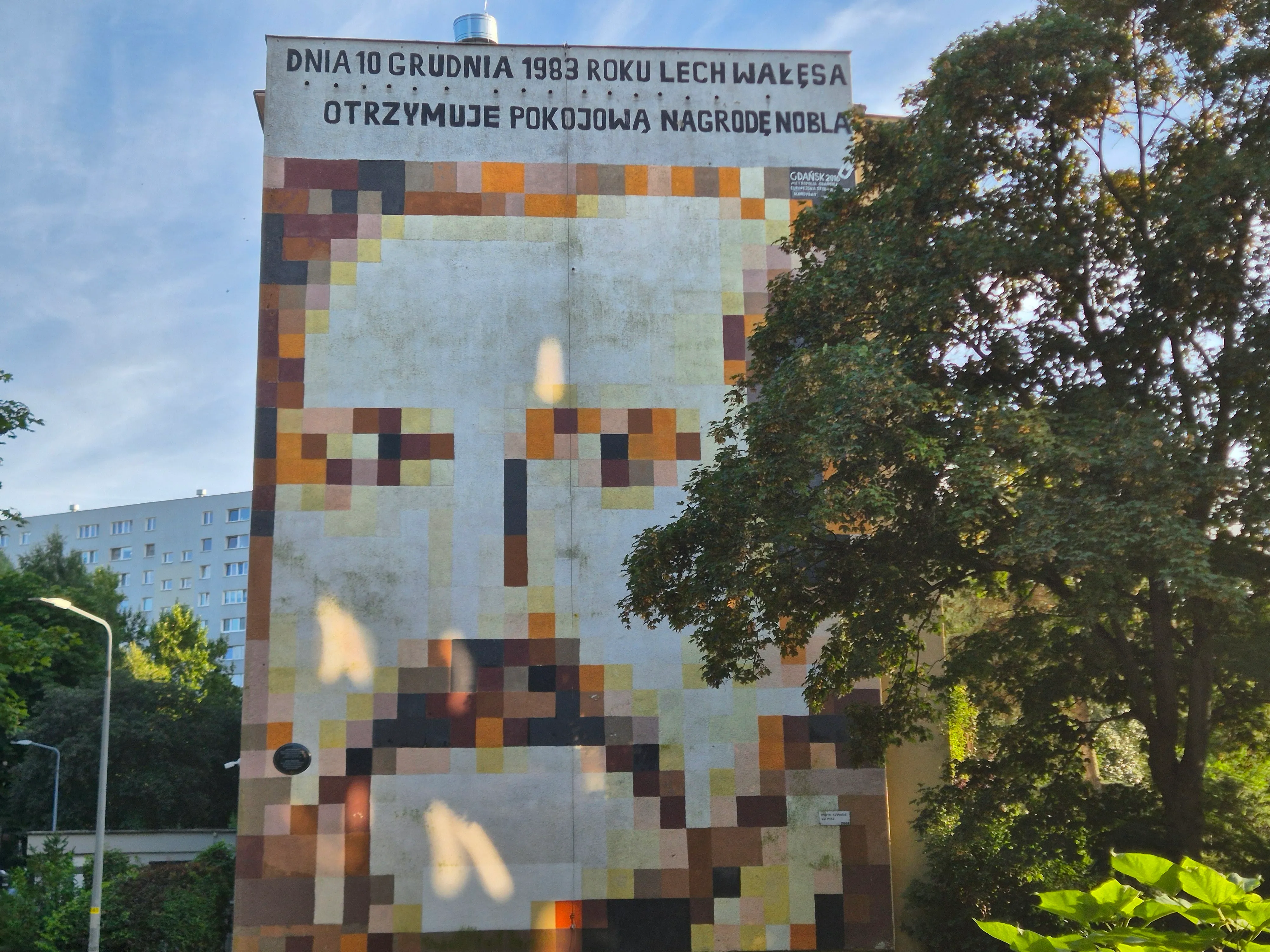 Pixelated portrait mural of Lech Wałęsa with a plaque about his Nobel Peace Prize